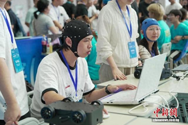 参赛选手调试脑机与应急机器人。 于琨 摄