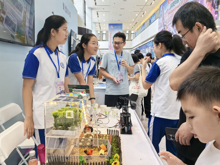 清华附中大兴学校展位前，学生向观众介绍自己的科创作品。新京报记者 杨菲菲 摄