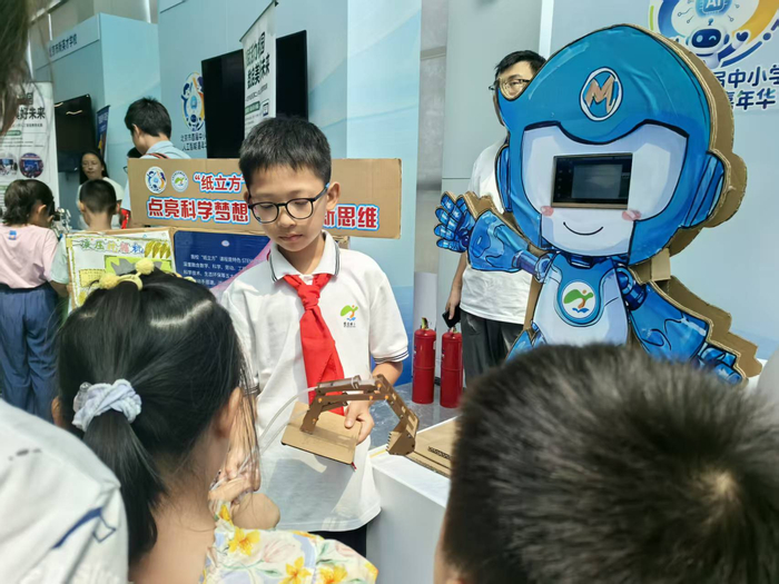 密云区新农村小学展区前，该校学生正在向观众展示科创作品。新京报记者 杨菲菲 摄